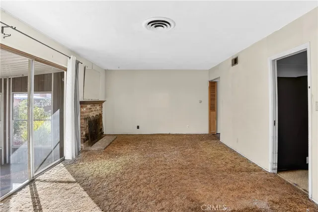 a view of a room with an empty space and wooden floor