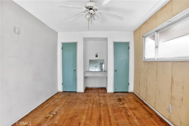 a bedroom with a bed and a chandelier fan