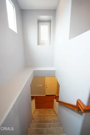 a view of a bedroom with wooden floor and stairs
