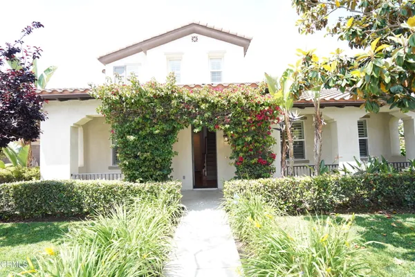 a view of a house with a yard and potted plants