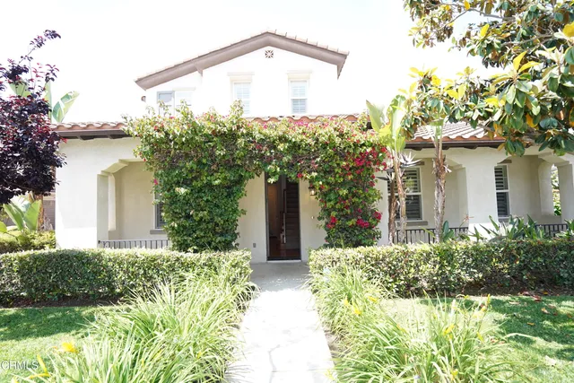 a view of a house with a yard and potted plants