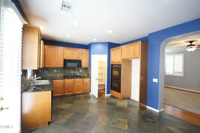wooden floor in white room with windows and ceiling fan