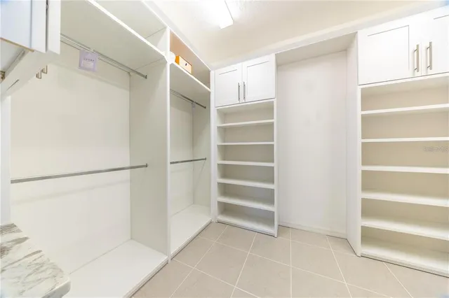 a view of walk in closet with empty racks