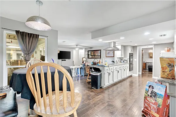 a kitchen with stainless steel appliances kitchen island granite countertop a sink cabinets and wooden floor