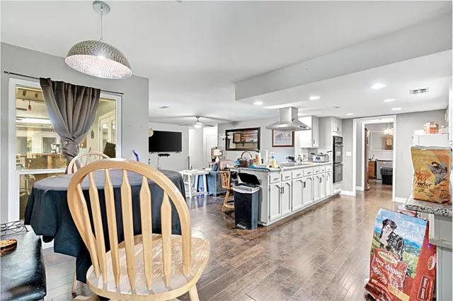 a kitchen with stainless steel appliances kitchen island granite countertop a sink cabinets and wooden floor