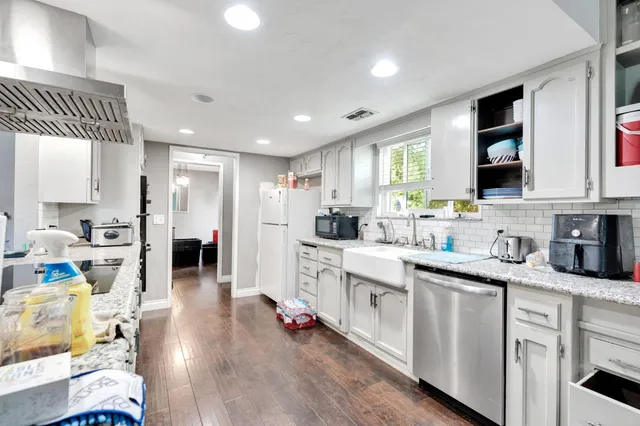 a kitchen with sink stove top oven and cabinets
