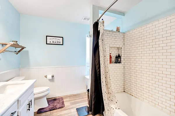 a bedroom with a bed and dresser with mirror