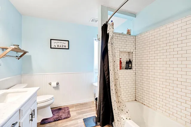 a bedroom with a bed and dresser with mirror