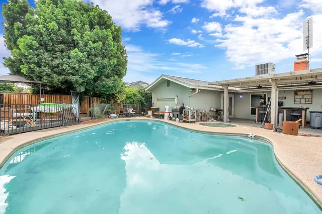 a view of a swimming pool with a patio and a garden