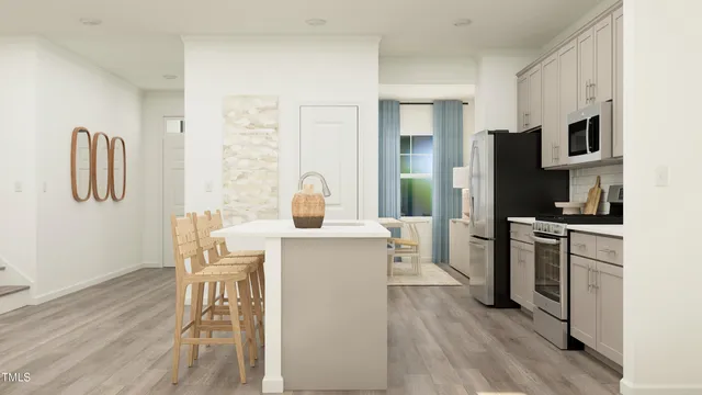 a kitchen with stainless steel appliances a stove a sink a refrigerator a table and chairs