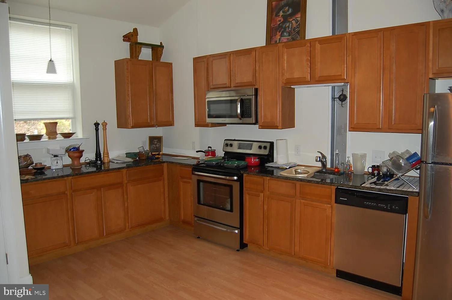 85 Valley Road, Unit 1 Phoenixville, PA 19460 - Photo 6 of 28 a kitchen with stainless steel appliances granite countertop a stove top oven a sink dishwasher and a refrigerator