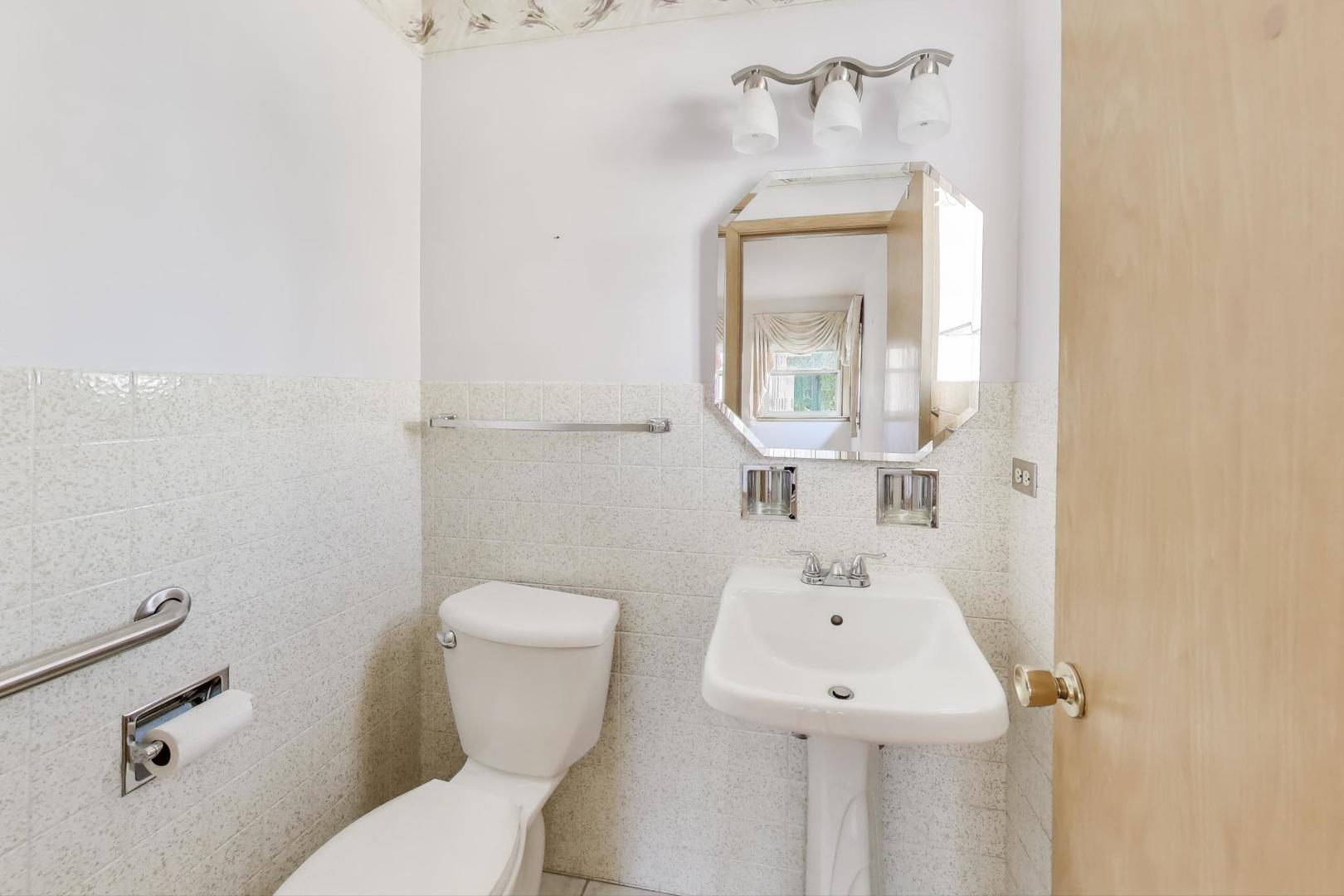 Undisclosed Address Chicago, IL 60656 - Photo 17 of 37 a bathroom with a sink mirror and toilet