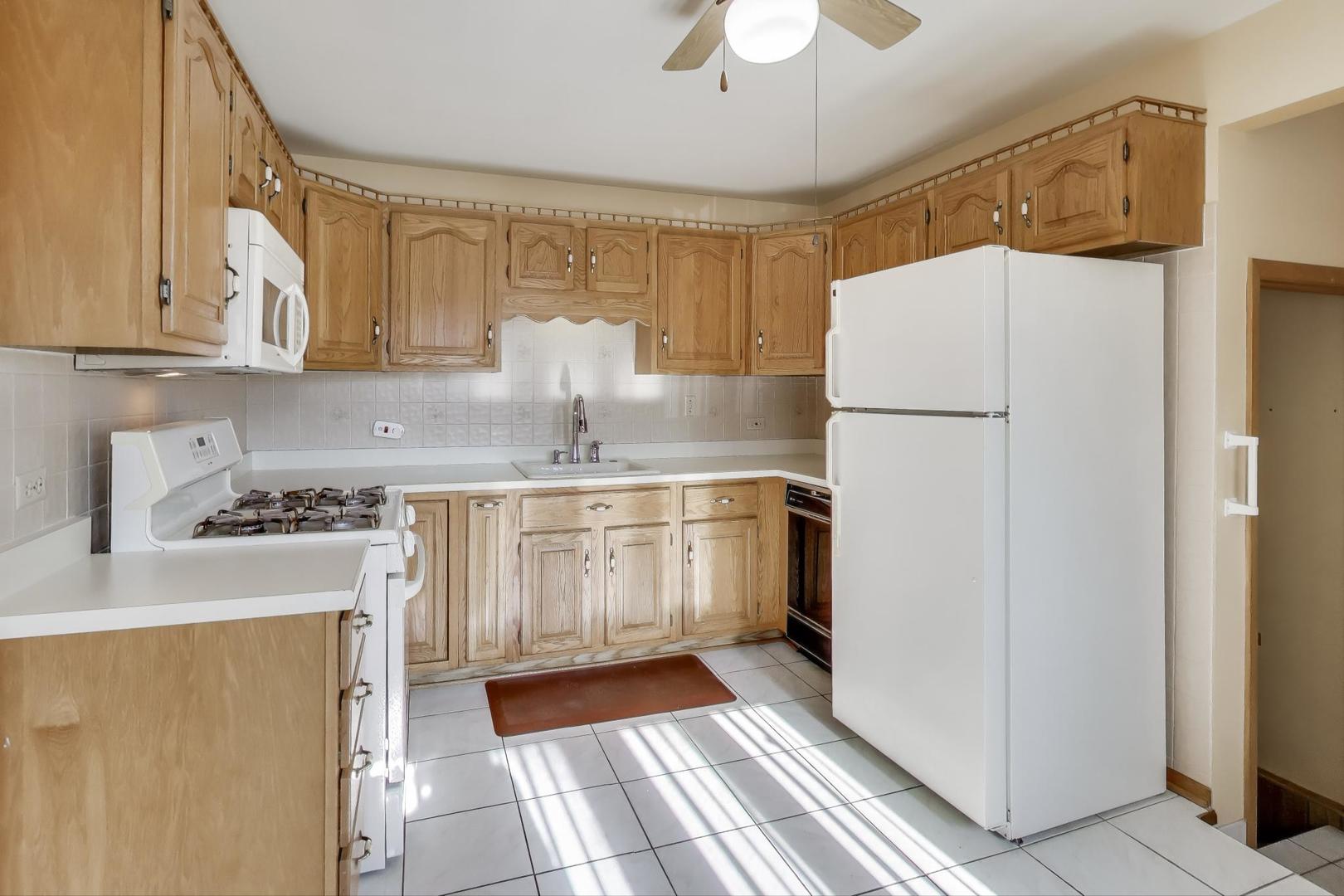 Undisclosed Address Chicago, IL 60656 - Photo 10 of 37 a kitchen with a sink a refrigerator and cabinets