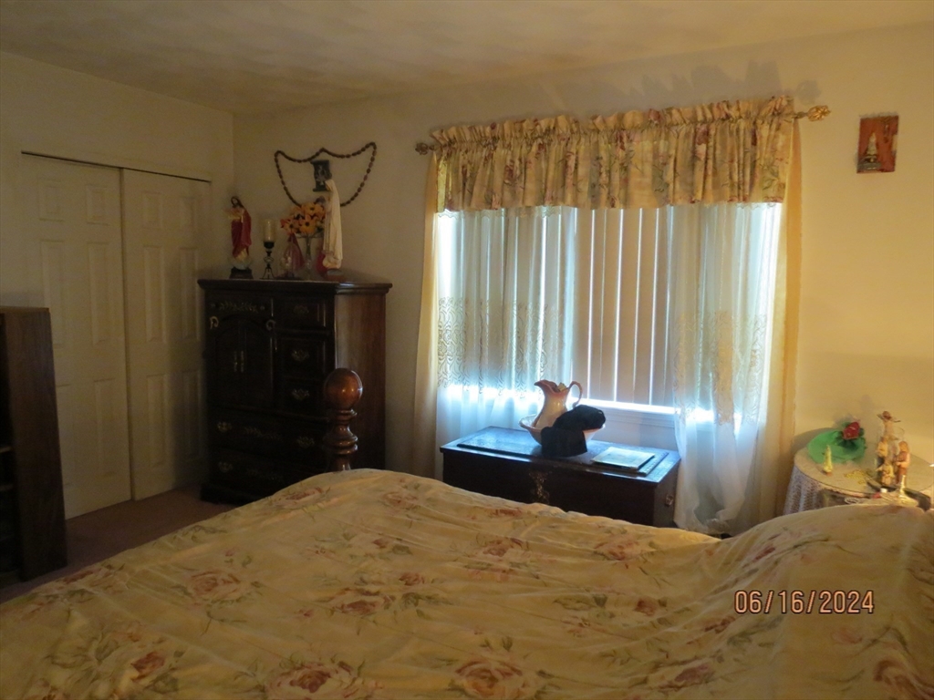 262 Acropolis Road Lowell, MA 01854 - Photo 19 of 31 a bedroom with a bed and a chandelier