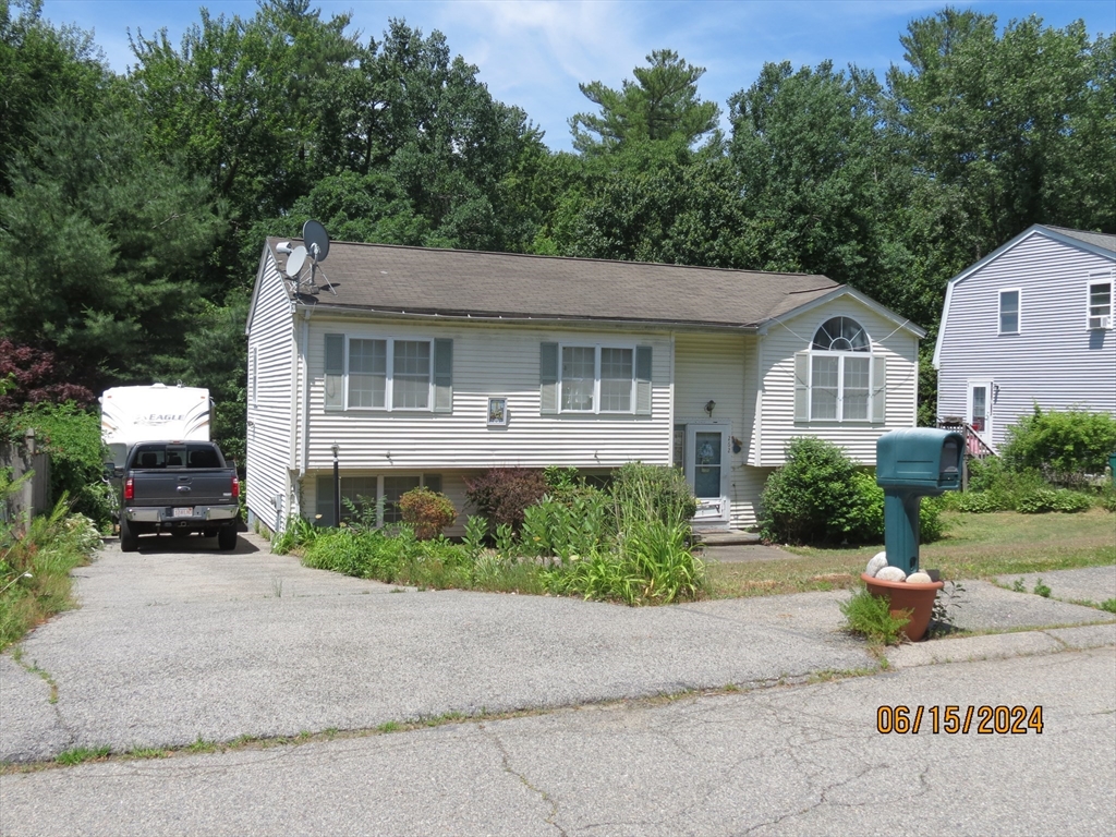 262 Acropolis Road Lowell, MA 01854 - Photo 2 of 31 a front view of a house with a yard and potted plants