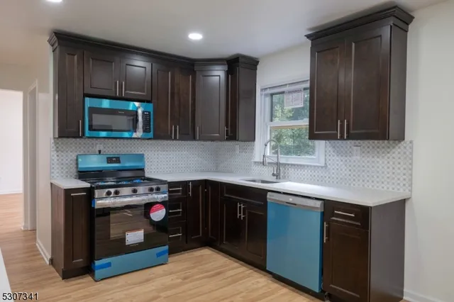 a kitchen with stainless steel appliances granite countertop wooden cabinets stove top oven and sink
