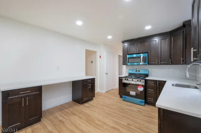 a kitchen with stainless steel appliances granite countertop a refrigerator stove top oven and sink