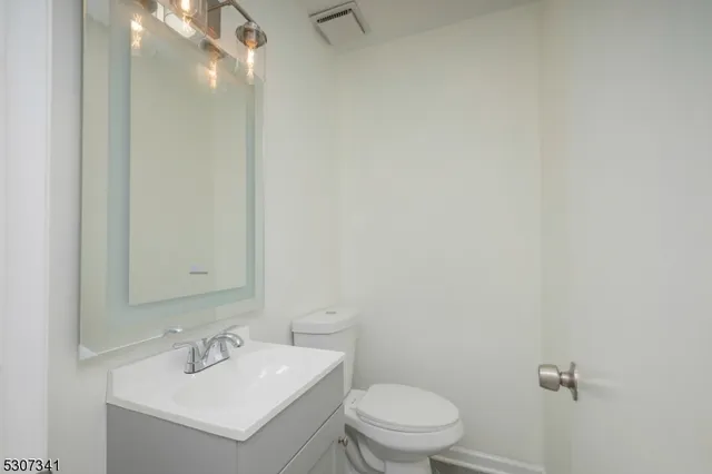a bathroom with a toilet a sink and mirror