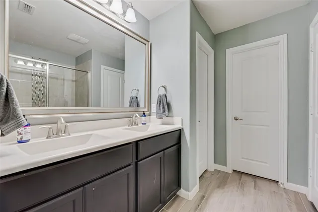 a bathroom with a double vanity sink and mirror