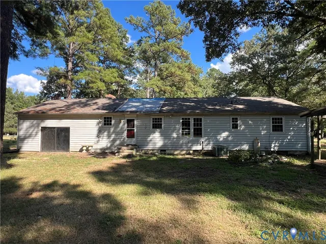 a front view of house with yard and trees in the background