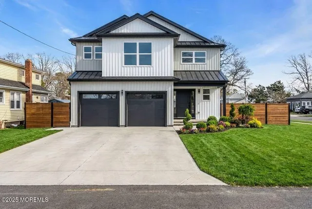 a front view of a house with a yard and trees