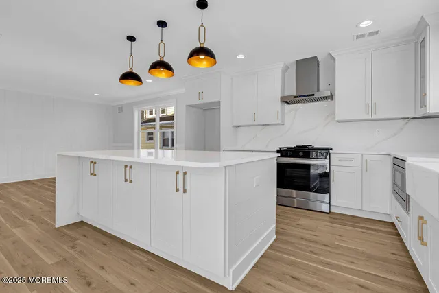 a kitchen with stainless steel appliances granite countertop a sink a stove and cabinets