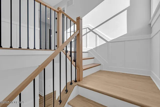 a view of staircase with wooden floor and white walls