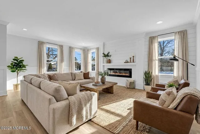 a living room with furniture a large window and a fireplace