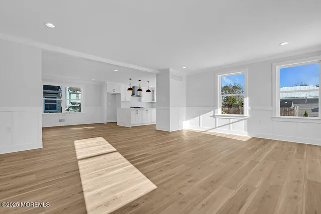 a view of empty room with wooden floor and window