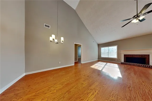 a view of empty room with wooden floor and fireplace