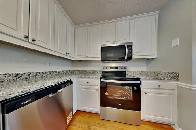 a kitchen with stainless steel appliances granite countertop a stove a microwave and oven