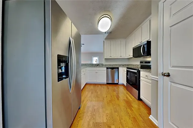 a kitchen with kitchen island a stove top oven a sink and a refrigerator