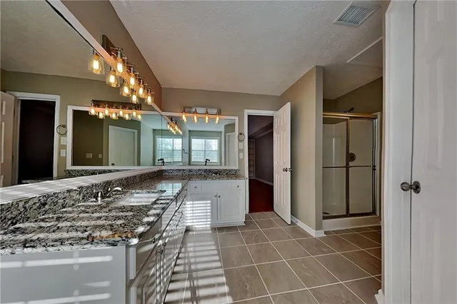 a bathroom with a granite countertop sink and a mirror
