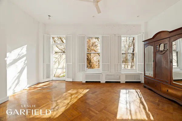a view of an empty room with a fireplace and a window