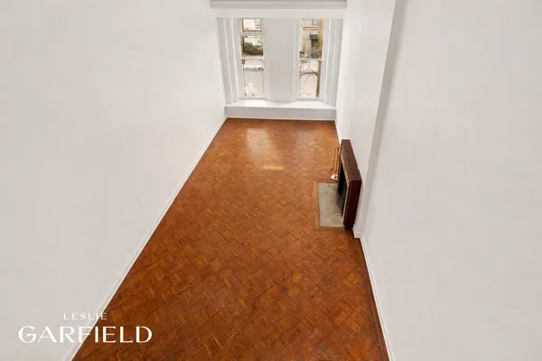 a view of an empty room with a fireplace and a window