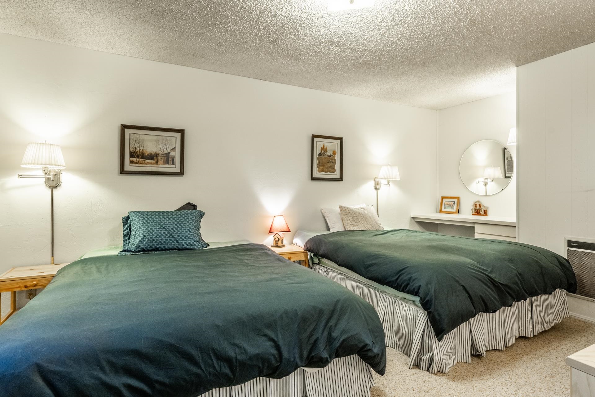 50 Hidden Valley Road, Unit 17 Mammoth Lakes, CA 93546 - Photo 27 of 40 Room featuring two single beds with striped bed skirts, wall-mounted light fixtures, a built-in vani