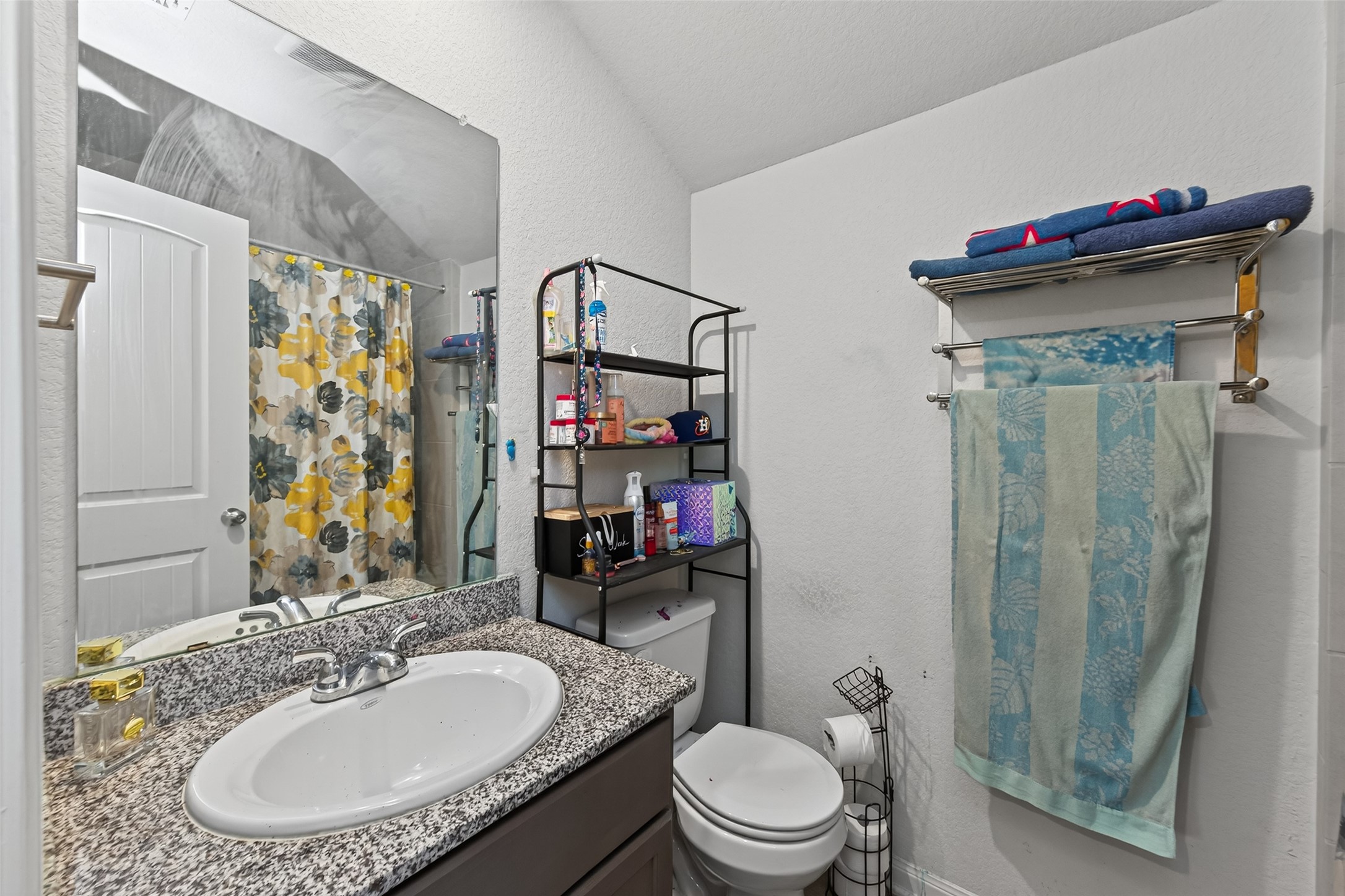 16601 Crosby Street Conroe, TX 77303 - Photo 36 of 50 Upstairs full bathroom with a granite vanity, ample storage, and a tub/shower combo with decorative tile surround.