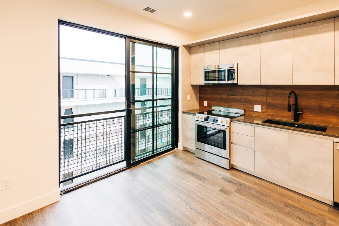 4315 South Congress Avenue, Unit 520 Austin, TX 78745 - Photo 1 of 14 a kitchen with stainless steel appliances granite countertop a stove a sink and a microwave