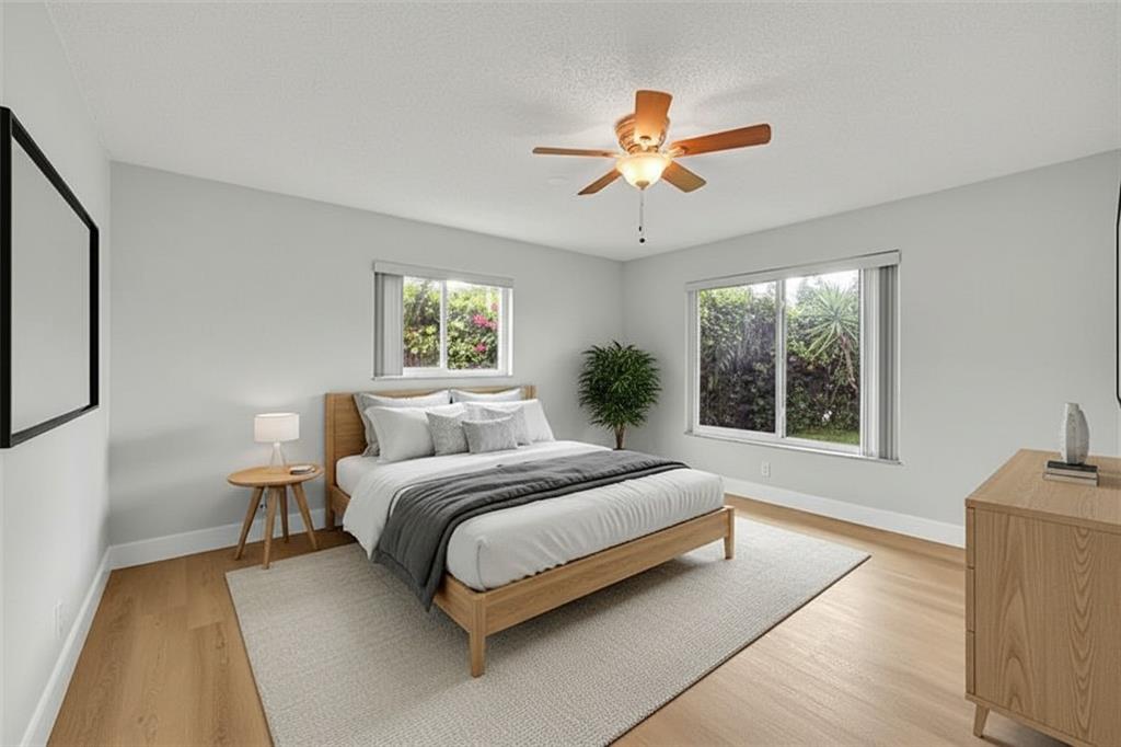 1480 Southwest 66th Terrace Plantation, FL 33317 - Photo 20 of 73 a spacious bedroom with a large bed and a chandelier