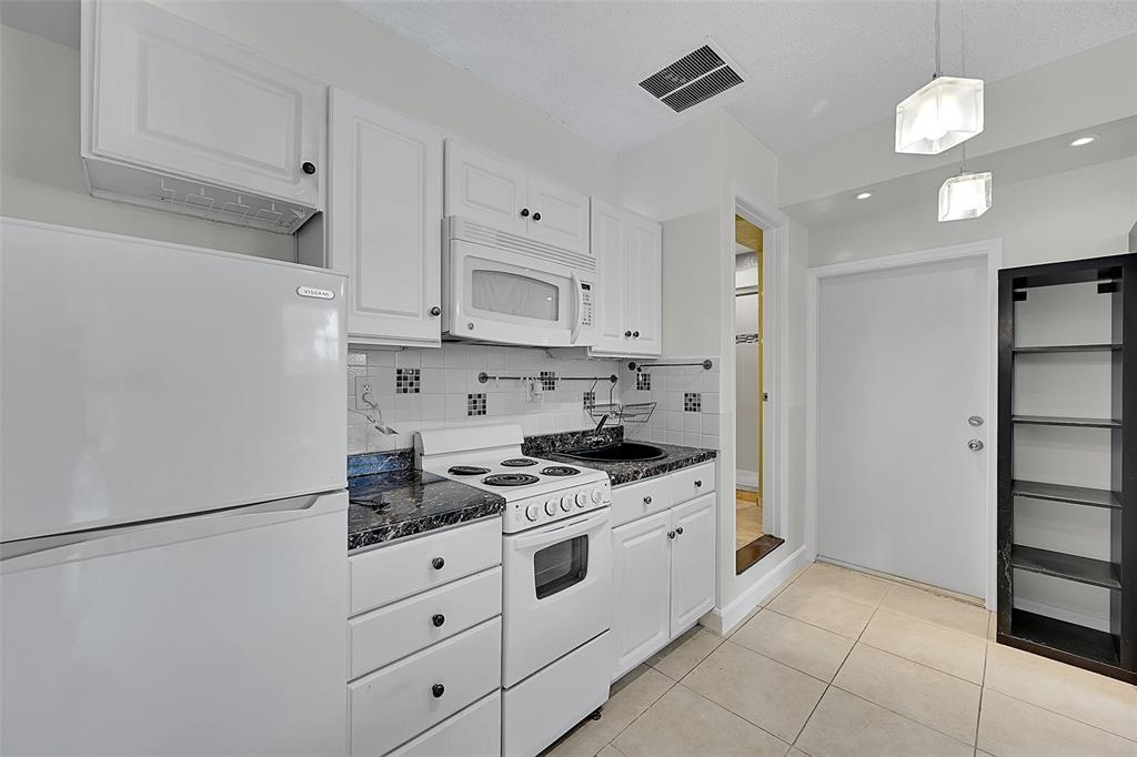 1480 Southwest 66th Terrace Plantation, FL 33317 - Photo 42 of 73 a kitchen with stainless steel appliances granite countertop a refrigerator sink and cabinets