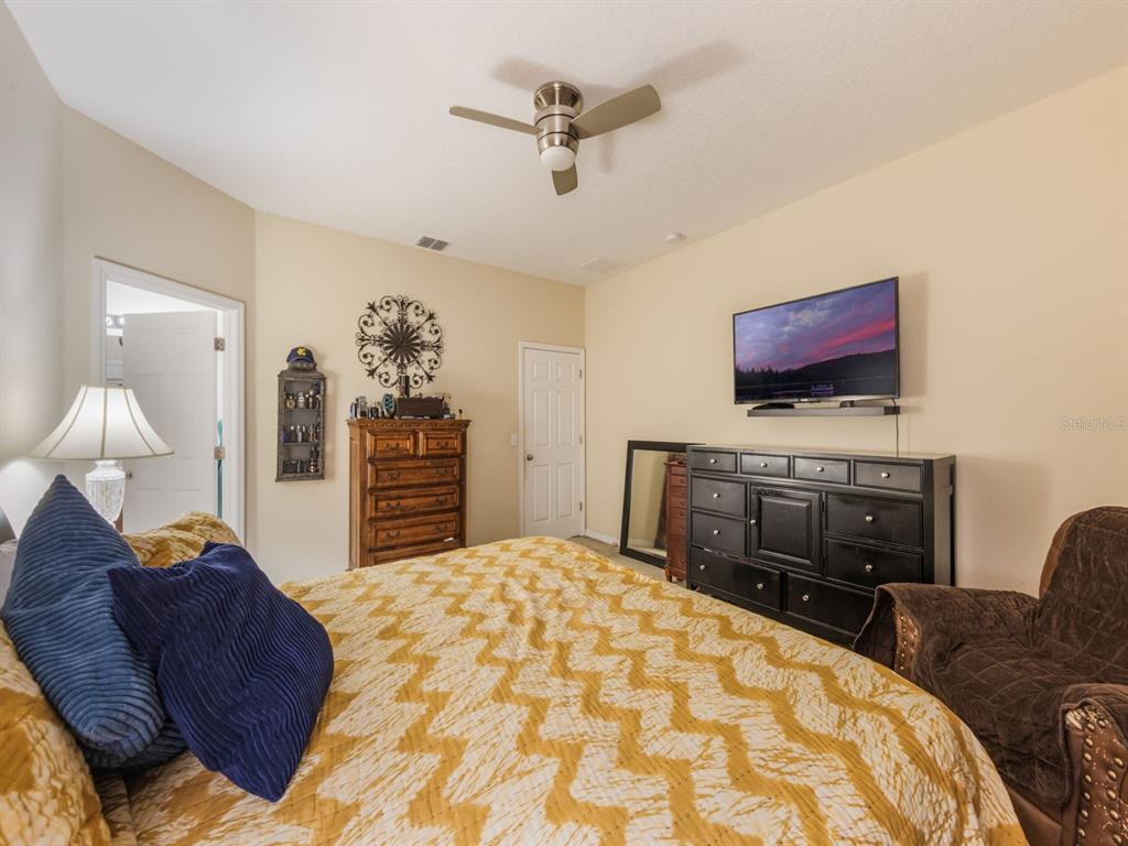 925 Counts Crest Circle Apopka, FL 32712 - Photo 22 of 36 a bedroom with a bed dresser and a flat screen tv