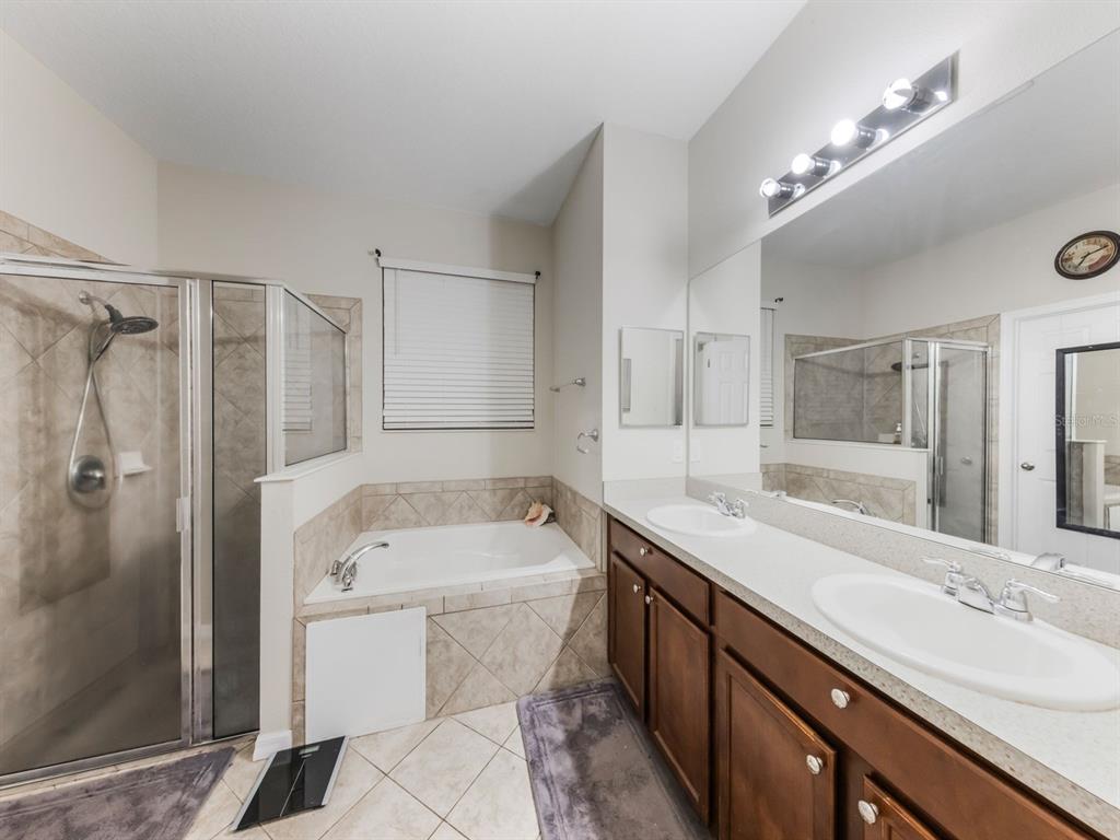 925 Counts Crest Circle Apopka, FL 32712 - Photo 24 of 36 a bathroom with a tub a sink double vanity and shower