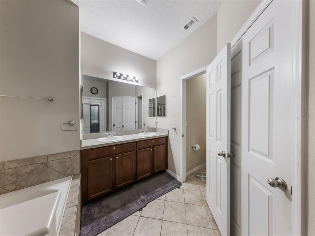 925 Counts Crest Circle Apopka, FL 32712 - Photo 25 of 36 a spacious bathroom with a double vanity sink a mirror and a bathtub