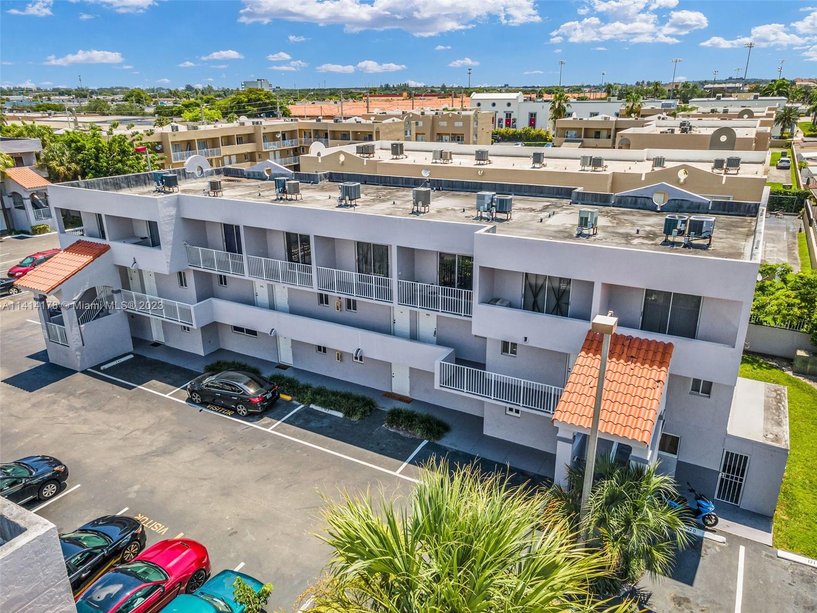 an aerial view of a balcony with outdoor seating and city view