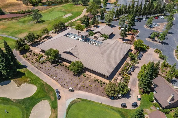 an aerial view of a house with a garden and lake view
