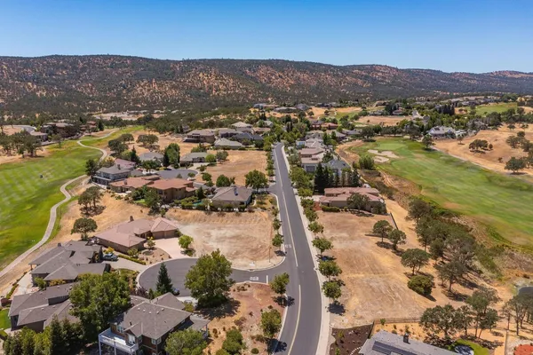 an aerial view of residential houses with outdoor space and trees