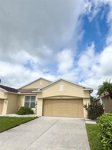 a front view of a house with a garden and garage