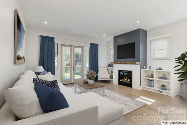a living room with furniture a fireplace and a flat screen tv