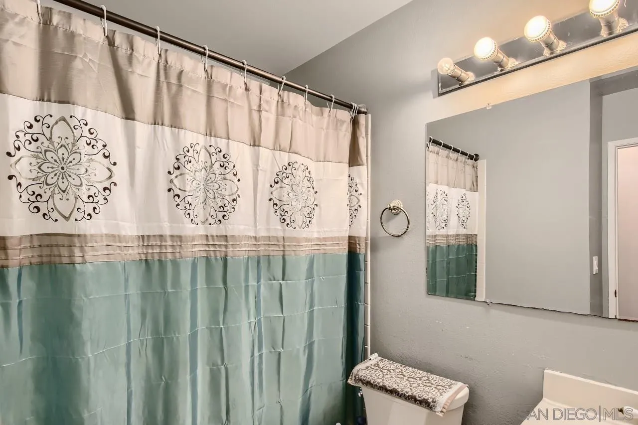 10027 Pebble Beach Drive Santee, CA 92071 - Photo 19 of 25 a bathroom with a shower curtain and a window