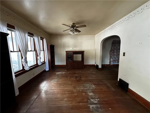a view of an empty room with window and fireplace